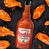 A bottle of Frank's RedHot Original Cayenne Pepper Sauce with chicken wings.
