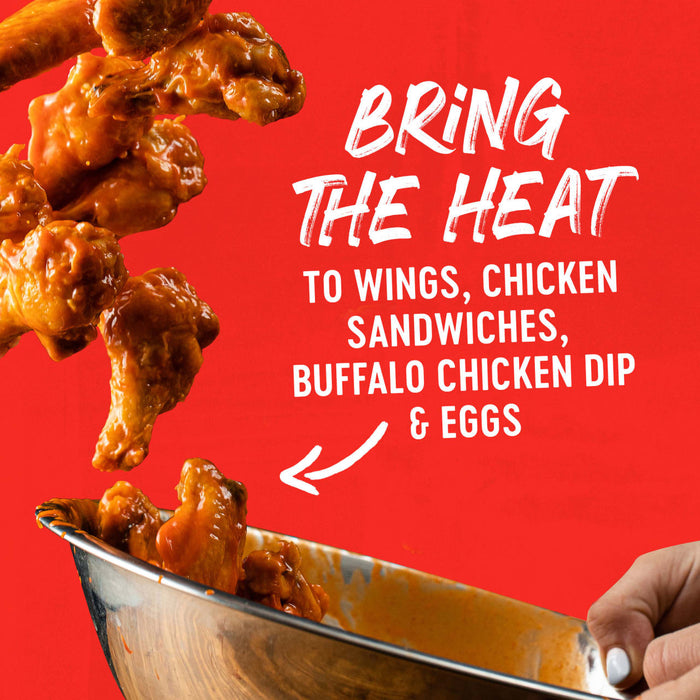 Buffalo wings are falling into a bowl with the text 'Bring the Heat to Wings, Chicken Sandwiches &amp; Buffalo Chicken Dip' on a red background.