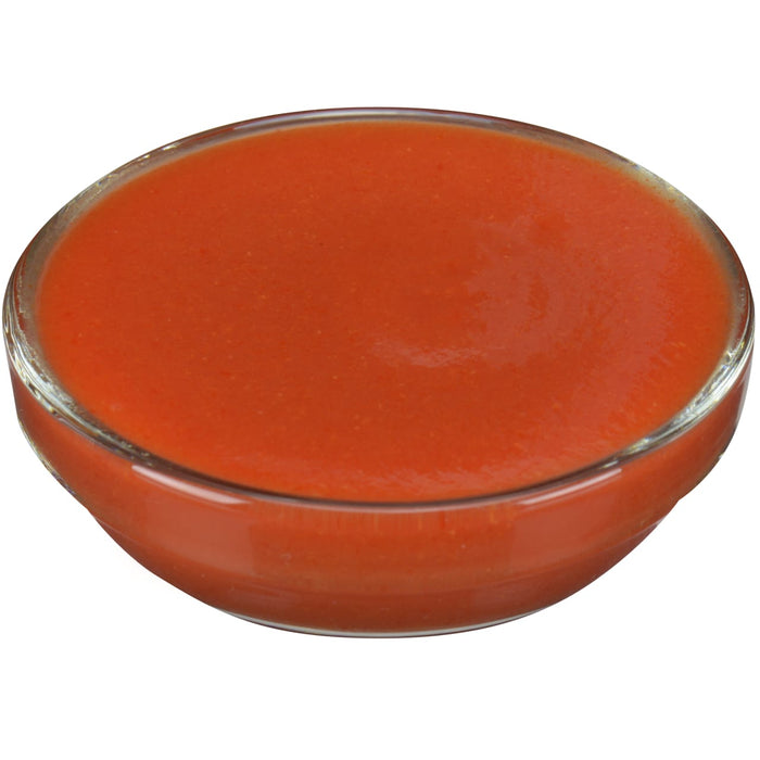 ['A glass bowl filled with a bright orange sauce.']