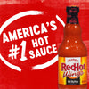 ["A bottle of Frank's RedHot Wings hot sauce with a red background that says America's #1 Hot Sauce."]