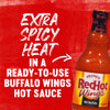 A bottle of Frank\'s RedHot Wings Hot Buffalo Sauce with the text Extra Spicy Heat in a Ready-to-Use Buffalo Wings Hot Sauce on a red background.