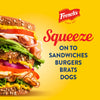A sandwich with mustard on it and the Frenchs logo with the text Squeeze onto sandwiches, burgers, brats, dogs.