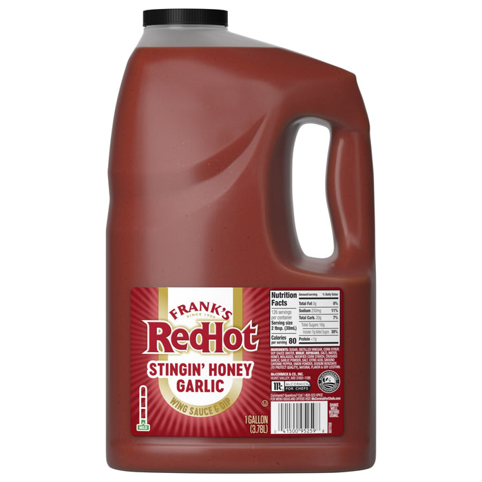 A one-gallon jug of Franks Red Hot Garlic Regular Hot Sauce Regular 128 Oz, with a red label identifying the flavor as Stingin' Honey Garlic Wing Sauce &amp; Dip.