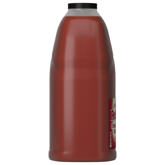 A side view of a large, 128-ounce jug of Franks Red Hot Garlic Regular Hot Sauce Regular 128 Oz, showing the red sauce and black cap.