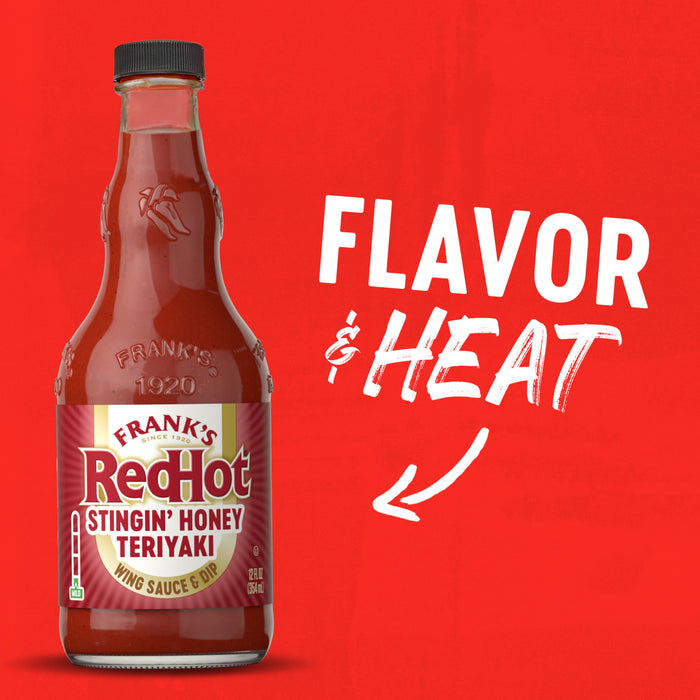A bottle of Franks Red Hot Stingin Honey Teriyaki Wing Hot Sauce Mild 12 Oz is displayed against a vibrant red background with the words FLAVOR and HEAT and a white arrow pointing toward the label.
