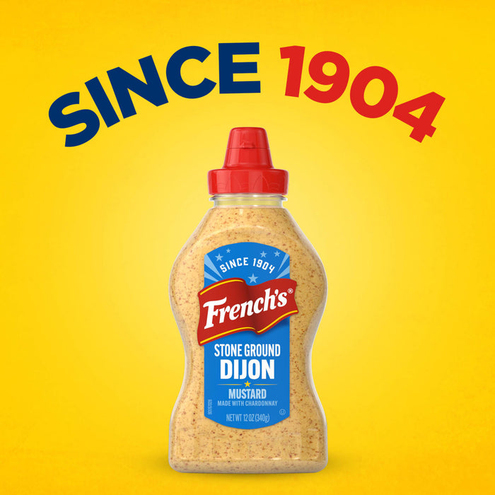 A bottle of Frenchs Beige Stone Ground Dijon Mustard 12 Oz is centered against a bright yellow background with the text SINCE 1904 arched above it.