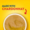 A top down view of a bowl filled with Frenchs Beige Stone Ground Dijon Mustard 12 Oz against a bright yellow background with text stating it is made with Chardonnay.