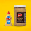 A small squeeze bottle of Frenchs Beige Stone Ground Dijon Mustard 12 Oz stands next to a large 32 ounce bulk jar of the same stone ground mustard against a solid yellow background.