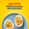 Two deviled eggs topped with paprika are displayed on a blue plate against a yellow background to suggest using Frenchs Beige Stone Ground Dijon Mustard 12 Oz as a flavorful mix in ingredient.