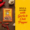 A package of Cholula Medium Chili Garlic Taco Seasoning Mix 1 Oz is displayed on a rustic wooden surface surrounded by fresh garlic cloves and dried red chili peppers against a bold yellow background with descriptive text.
