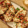 A platter of toasted molletes topped with melted cheese and a fresh pico de gallo salsa made using Cholula Medium Chili Garlic Taco Seasoning Mix 1 Oz.
