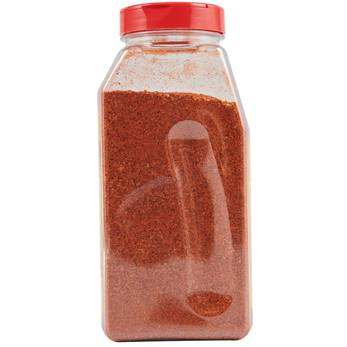 A clear plastic jar with a red lid filled with red chili powder.
