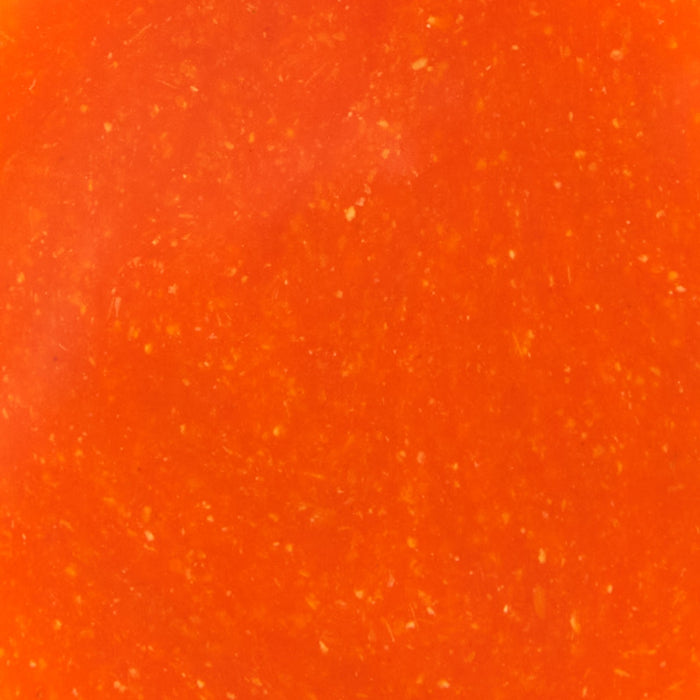A close-up of a bright orange sauce with small white flecks.