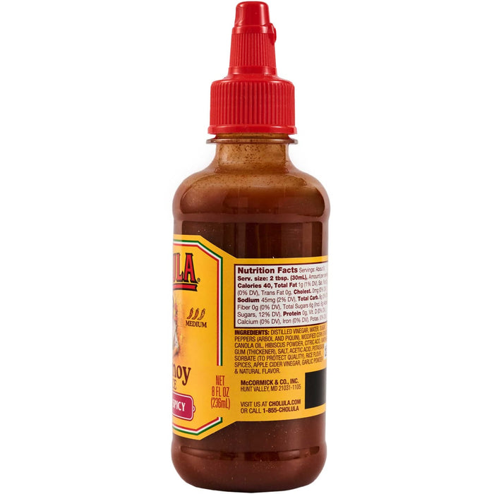 A bottle of Cholula hot sauce with a red cap and a label showing nutrition facts and ingredients.