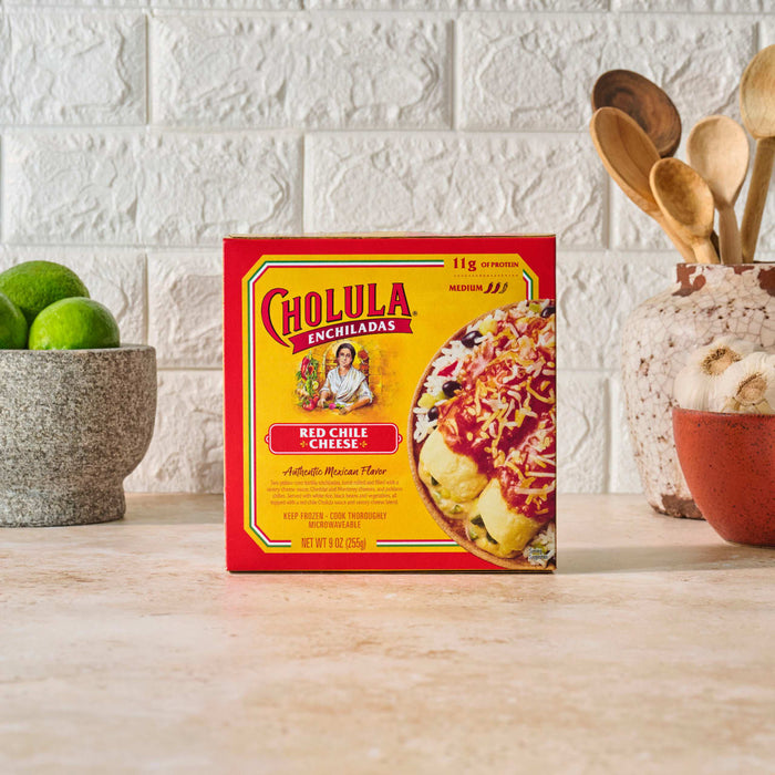 A box of Cholula Fiesta Ranch Dip Mix sits on a counter next to limes and kitchen utensils.