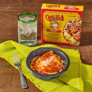 A Cholula-branded meal kit is displayed with a prepared serving a drink and a fork suggesting a convenient and flavorful dining experience.