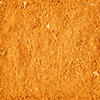 A close-up of reddish-brown dirt or soil texture.
