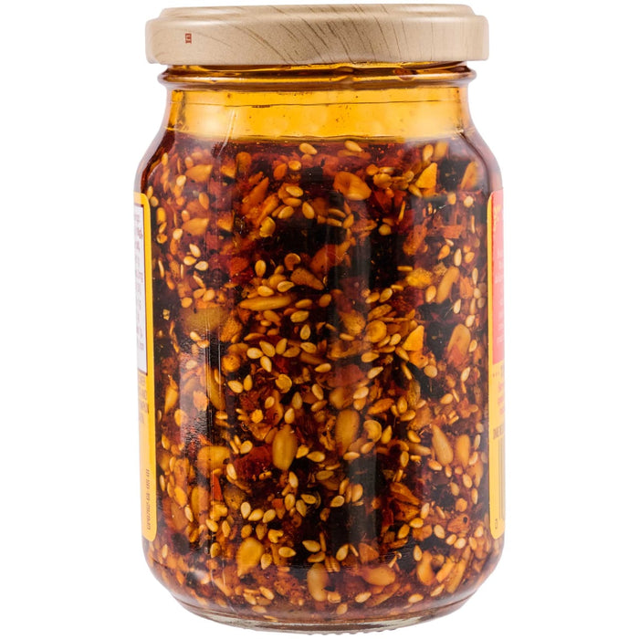 A jar of chili oil with sunflower, ricotta, and pumpkin seeds.
