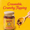 A jar of Cholula Chili Crisp Sauce is displayed next to a wooden spoon holding the sauce with the text Craveable Crunchy Topping above.