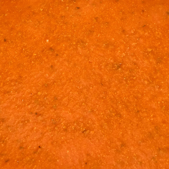 A close-up shot of a vibrant orange textured surface possibly a sauce or paste.
