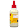 A bottle of Cholula Creamy JalapeA?o Lime hot sauce.
