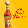 A bottle of Cholula Original Hot Sauce with the text Uncap Real Flavor in the background.