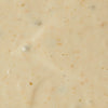 A close-up of a creamy white sauce with small brown flecks.