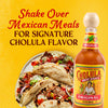 A bottle of Cholula Original Hot Sauce stands next to a plate of tacos, with text encouraging shaking it over Mexican meals for signature flavor.