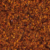 A close-up of a blend of spices including red pepper flakes salt and other herbs.