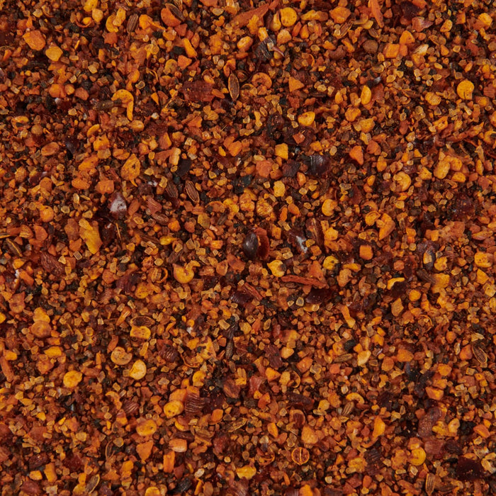 A close-up of a blend of spices including red pepper flakes salt and other herbs.