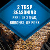 The image shows a close-up of seasoned steak, burgers, or pork on a grill, with a blue diamond-shaped overlay stating 2 TBSP Seasoning Per 1 LB Steak, Burgers, or Pork.