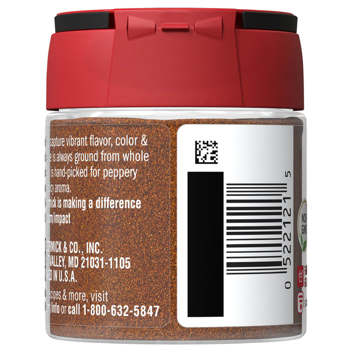 A glass jar of McCormick ground pepper with a red lid.