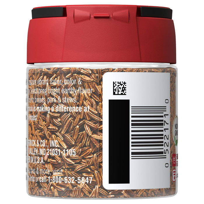 A glass jar of McCormick Caraway Seeds with a red lid.