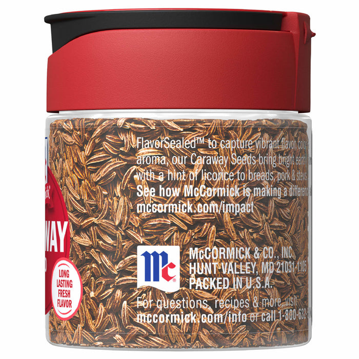 A glass jar of McCormick Caraway Seeds with a red lid.