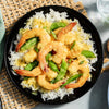 A plate of shrimp with rice and green beans.