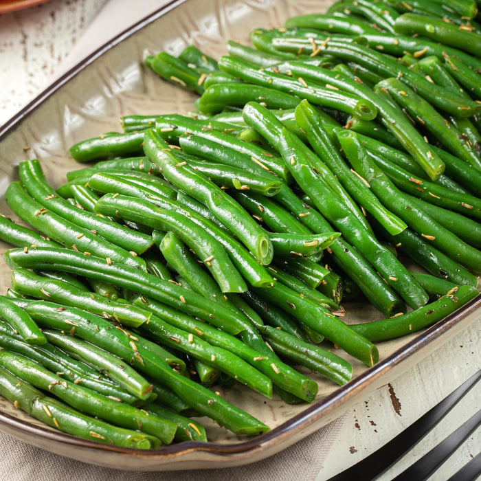 A plate of green beans seasoned with herbs.