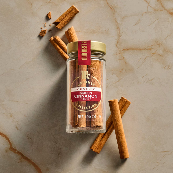 A jar of Royal Cinnamon Sticks is displayed on a marble surface with scattered cinnamon sticks.