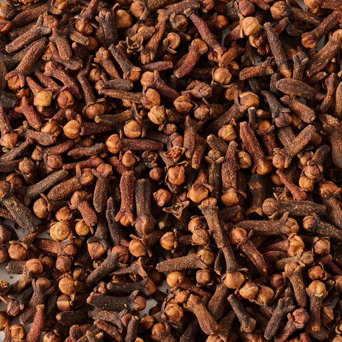 A close-up view of dried cloves, showcasing their distinctive shape and rich brown color.