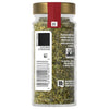 A jar of PC brand dried basil with a label and barcode.