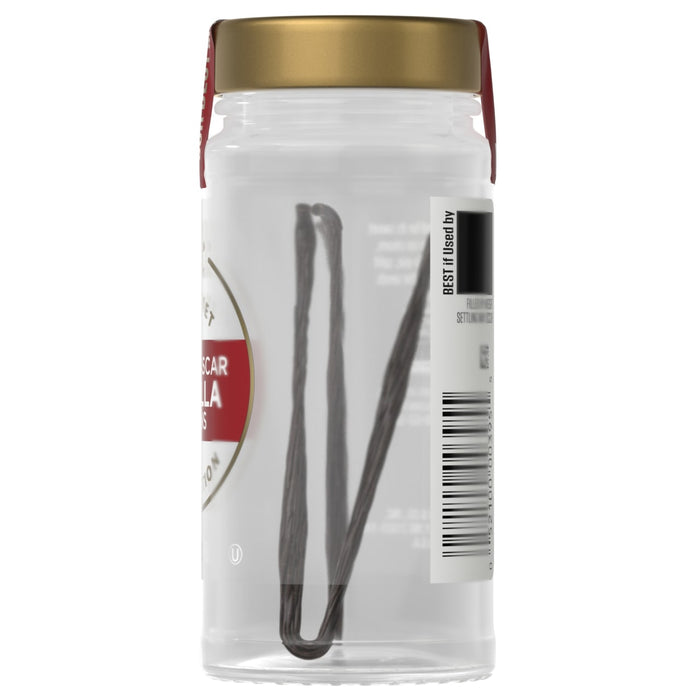 A jar of Stella Artois olives with a pair of tongs inside.