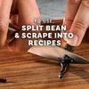 A vanilla bean is being split and scraped with a knife to extract the vanilla for use in recipes.