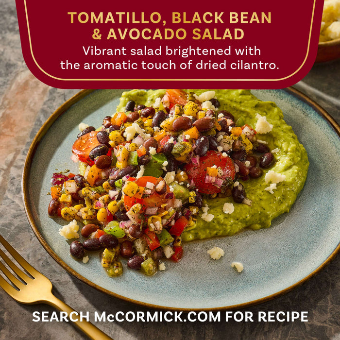 A plate of McCormick's Tomatillo, Black Bean &amp; Avocado Salad is shown, a vibrant salad brightened with the aromatic touch of dried cilantro.