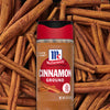 A jar of McCormick Cinnamon Ground spice is surrounded by cinnamon sticks.
