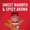 A bottle of McCormick Cinnamon Ground with cinnamon sticks on a red background.