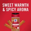 A bottle of McCormick Cinnamon Ground with cinnamon sticks on a red background.