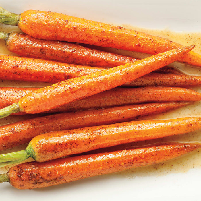 A close-up of several roasted carrots with a brown sugar glaze.