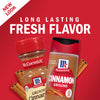 Two McCormick Cinnamon containers with cinnamon sticks on a red background.