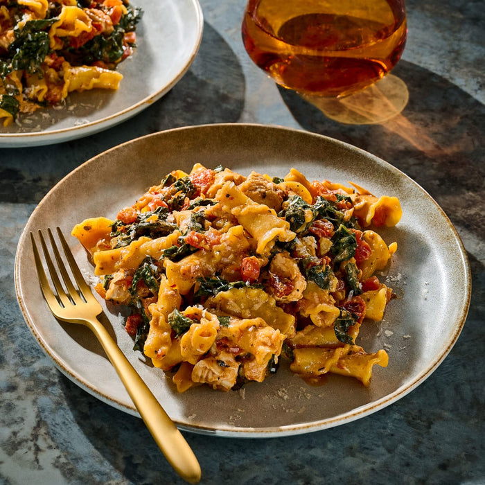 A plate of pasta with vegetables and sauce is shown, highlighting a delicious and appetizing meal.