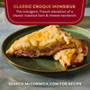 A close-up of a delicious McCormick Classic Croque Monsieur sandwich, showcasing its layers of ham and cheese.