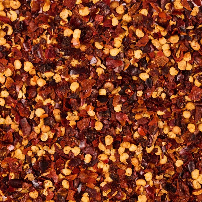 A close-up of crushed red pepper flakes, commonly used as a spice to add heat to dishes.